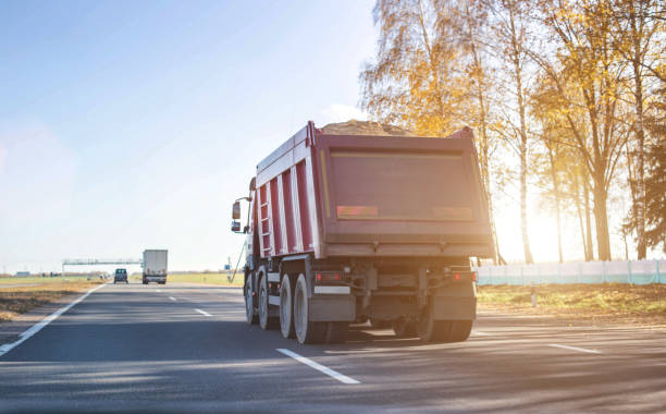 A 40 ton truck carries construction sand on the highway. Concept of overload on the roads and rental of a dump truck for work